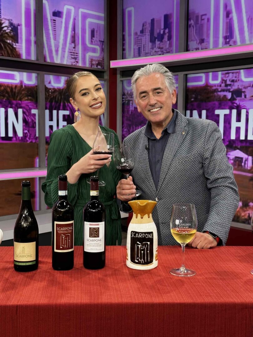 Two people posing with Scarpone wine Two people posing with Scarpone wine